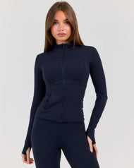Woman wearing a navy blue athletic outfit on a light gray background
