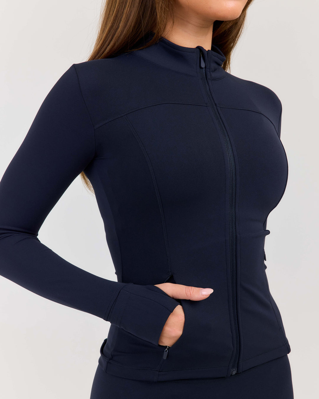 Navy blue athletic jacket worn by a person on a light gray background