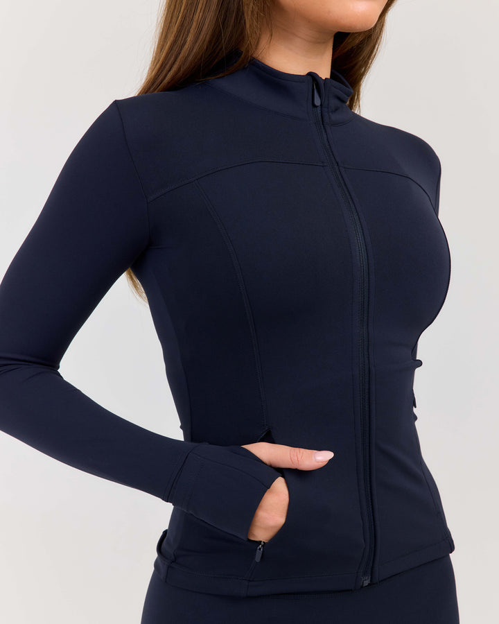 Navy blue athletic jacket worn by a person on a light gray background