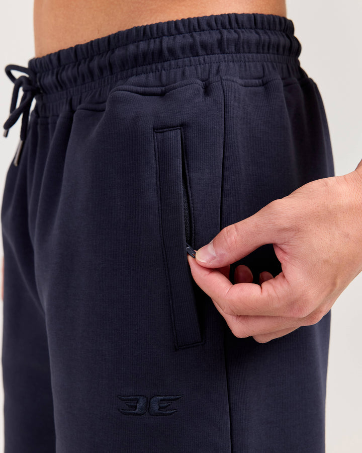 Navy blue shorts with a brand logo on a light gray background